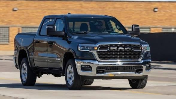 Dark blue Ram pickup truck parked on paved surface with brick building in background